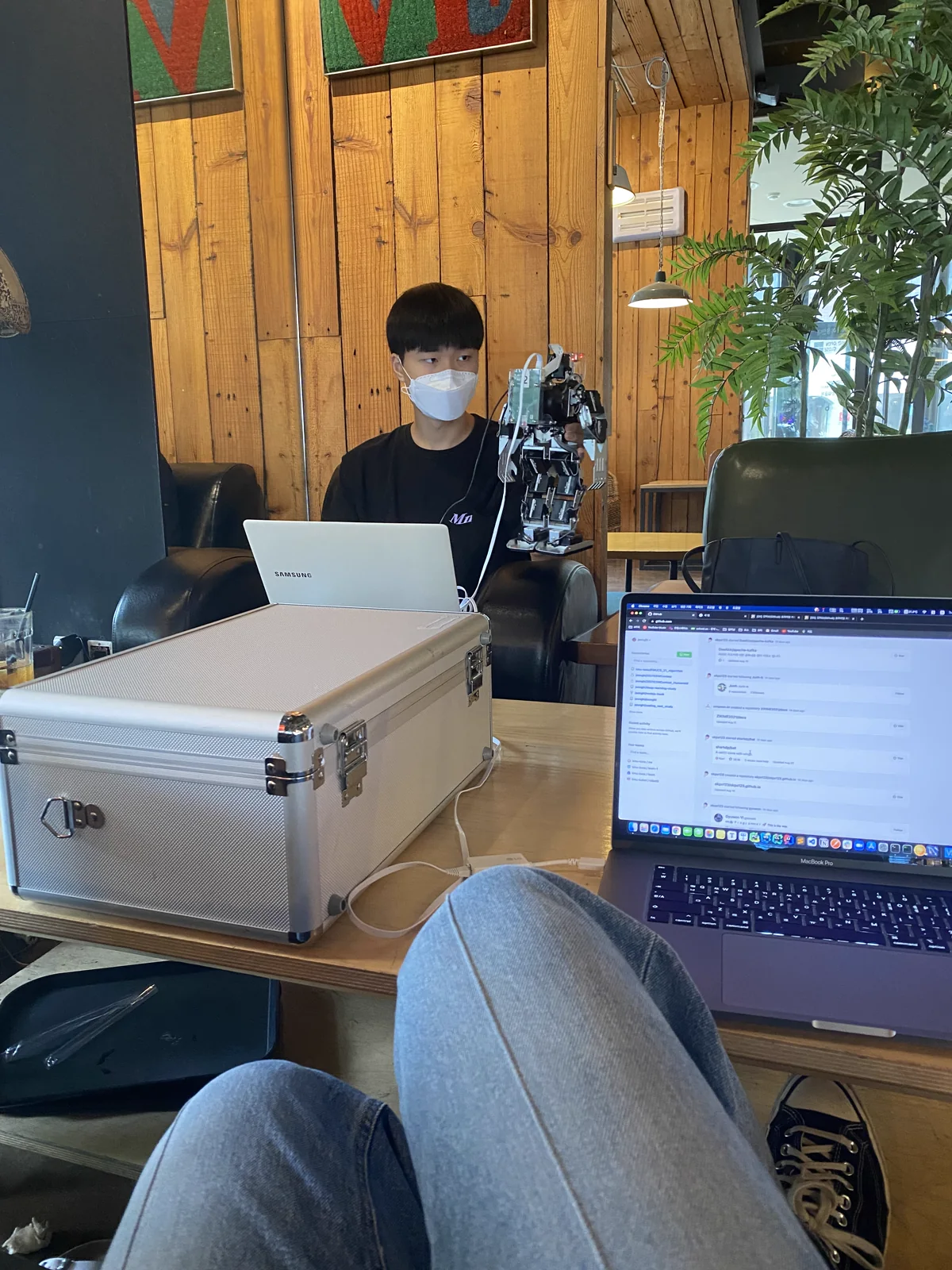 로봇 장비와 노트북을 테이블에 펼쳐 두고 작업하는 모습
