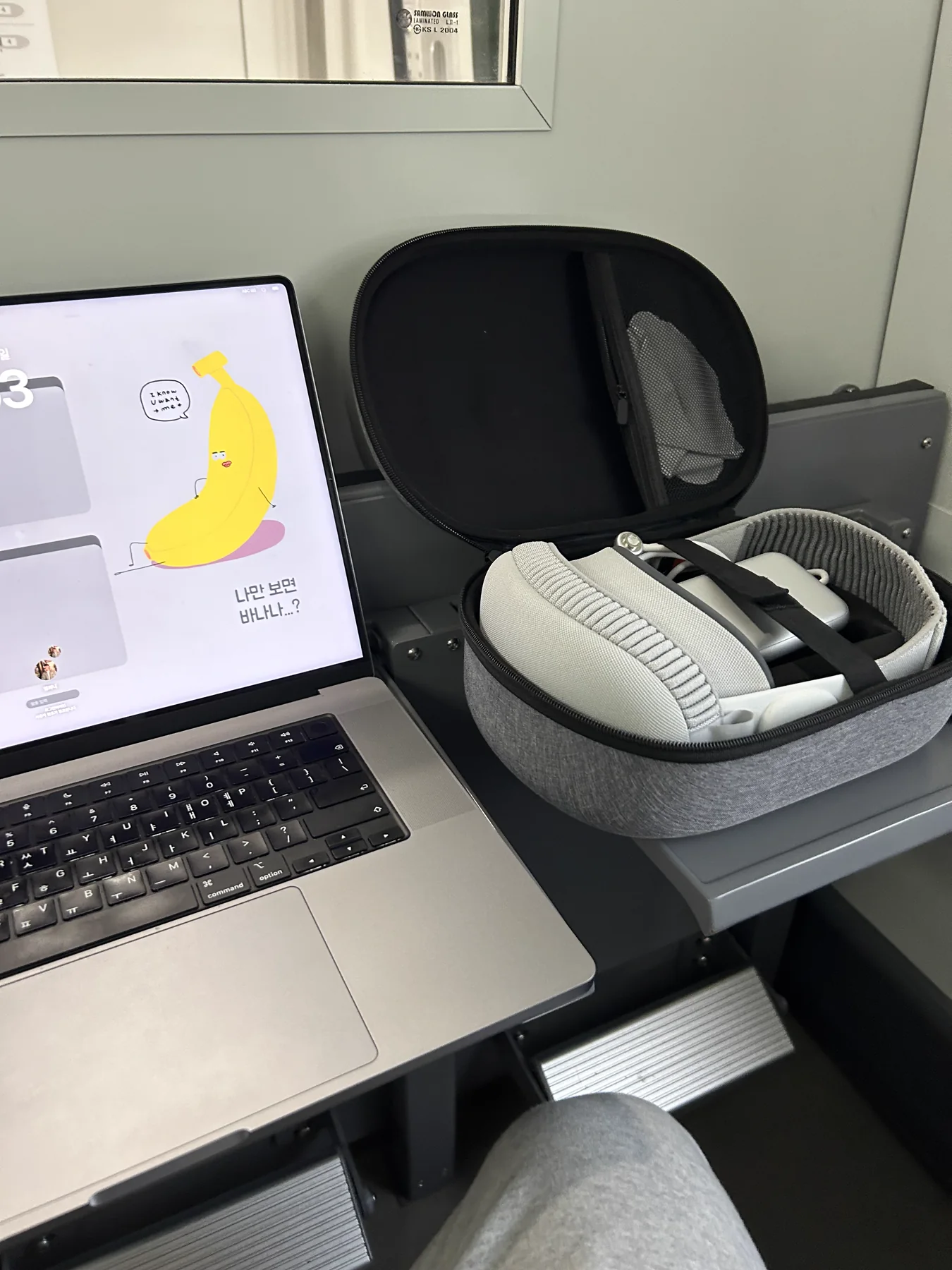 MacBook 옆에 열린 케이스에 Apple Vision Pro가 놓여 있는 모습